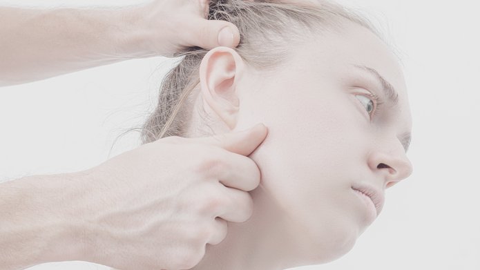 praca z wystawy - głowa kobiety i dotykające ją ręce