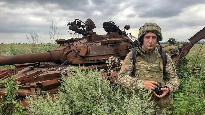 żołnierz stojący na tle czołgu na łące