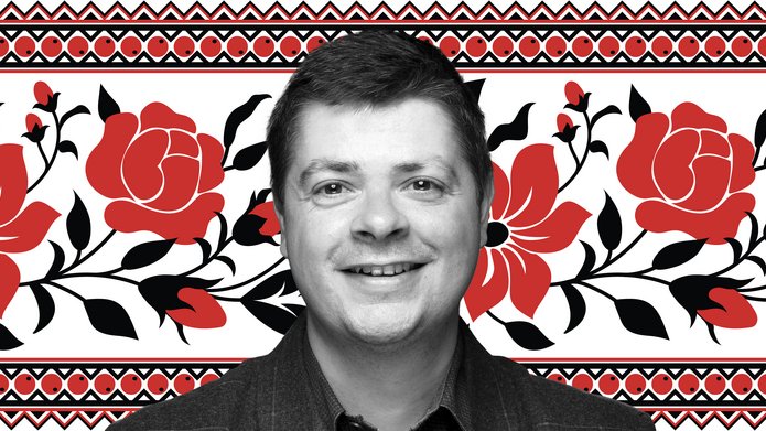 Dr Tomasz Lachowski na białym tle wypełnionym wzorem w czerwone kwiaty z czarnymi liśćmi