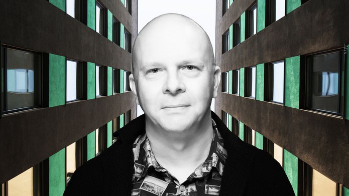 Portret dra Tomasza Napierały pomiędzy dwoma strzelistymi budynkami biurowymi